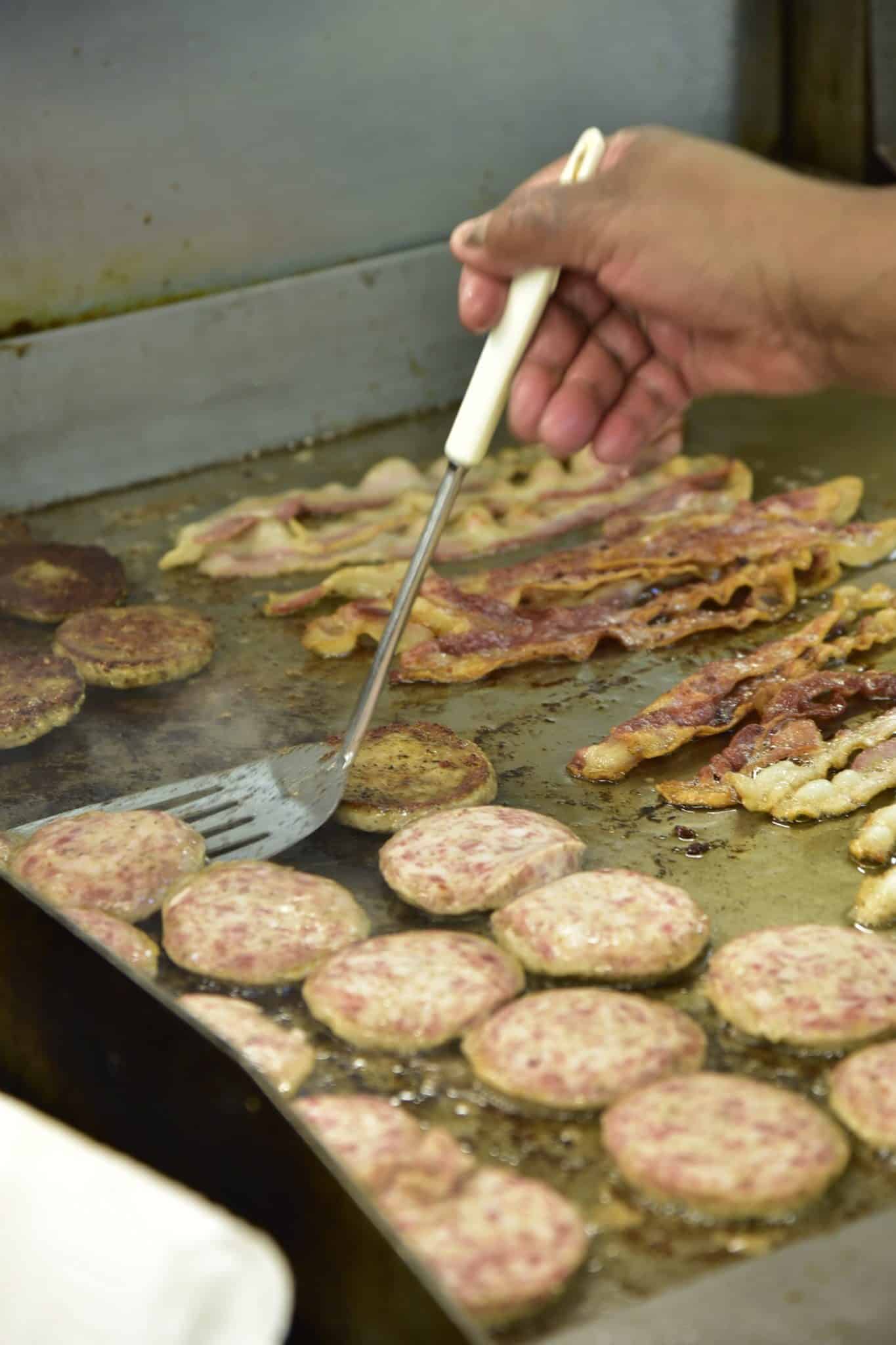 flipping sausage patties with a metal spatula